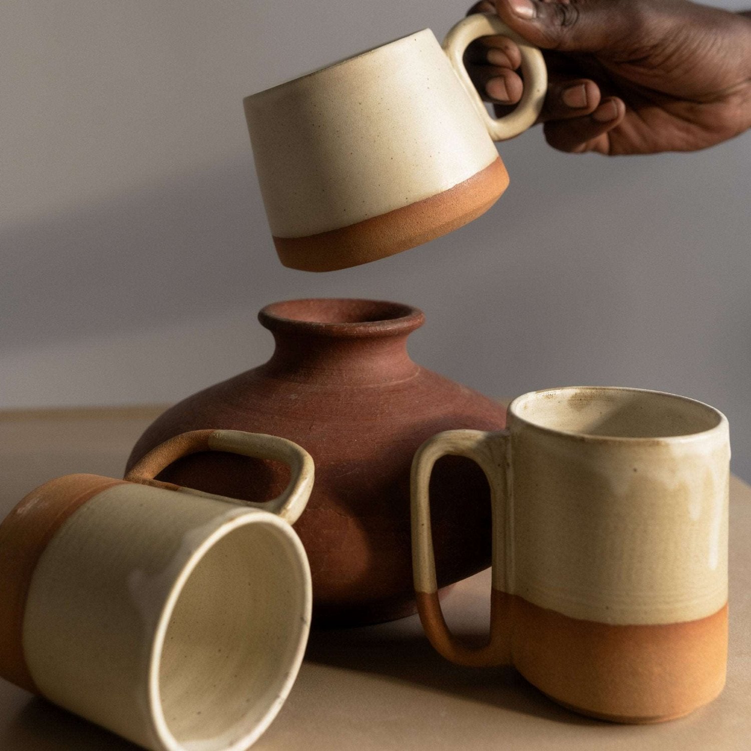 Hand-constructed coffee mug with a sleek conical design and creamy glaze.