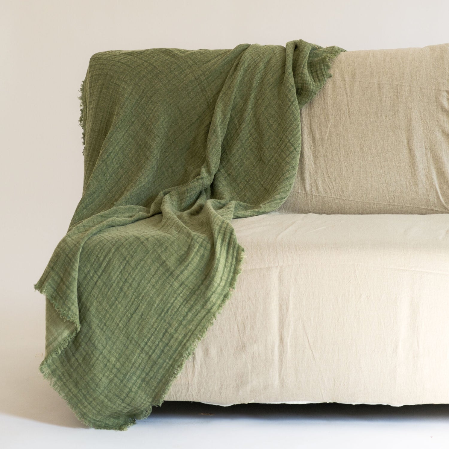 The green throw draped in a minimal aesthetic