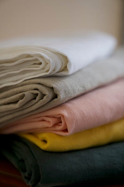 Pink linen sheet set paired with matching decor elements.