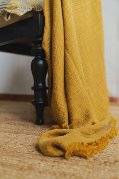 Close-up of the textured fabric and stitching details on Mustard Ochre linen and cotton slub throw