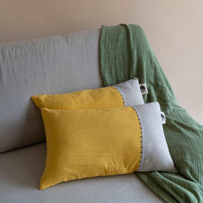 Front view of the oblong linen cushion cover featuring a half yellow and half sand beige design, displayed against a white background.