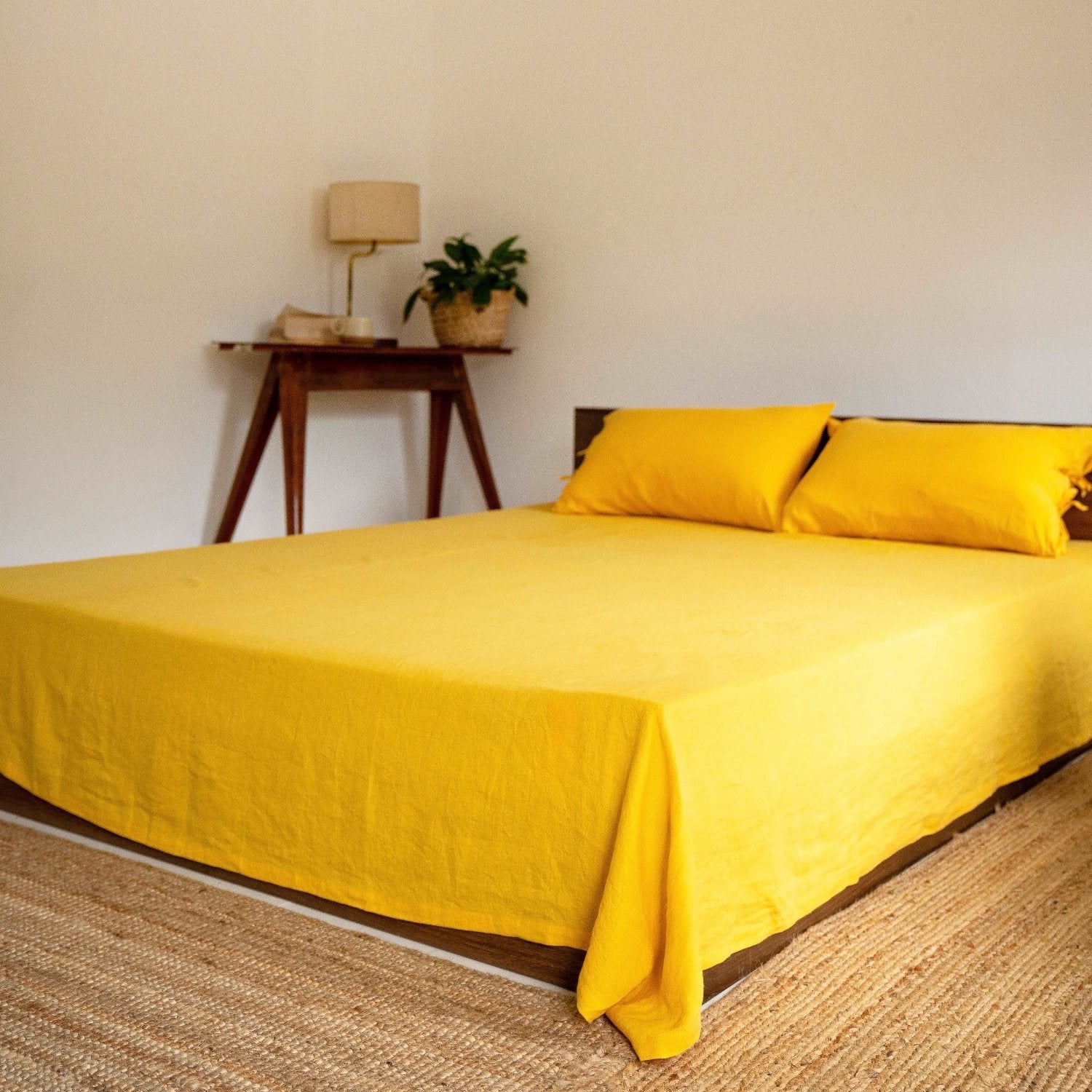 Golden yellow sheet set on a sunlit bed with natural accents.