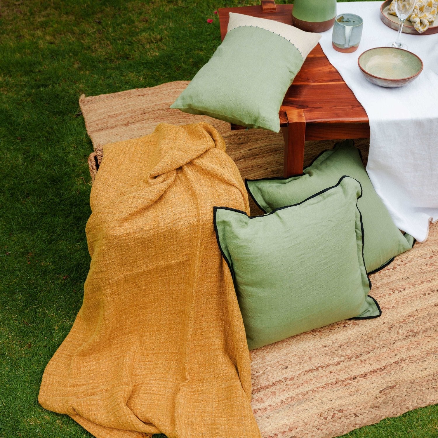 Olive green linen cushion cover styled with matching home accessories, creating a cohesive interior look