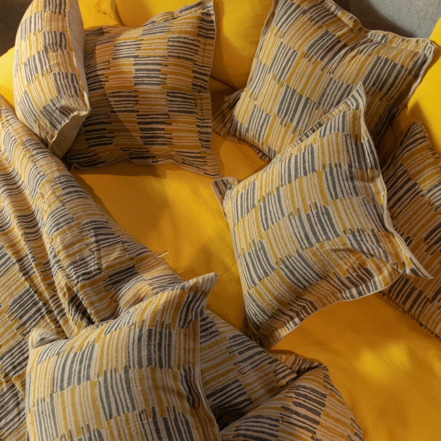 Top-down shot of Ochrewood quilt paired with a yellow sheet for a bright, sunny look