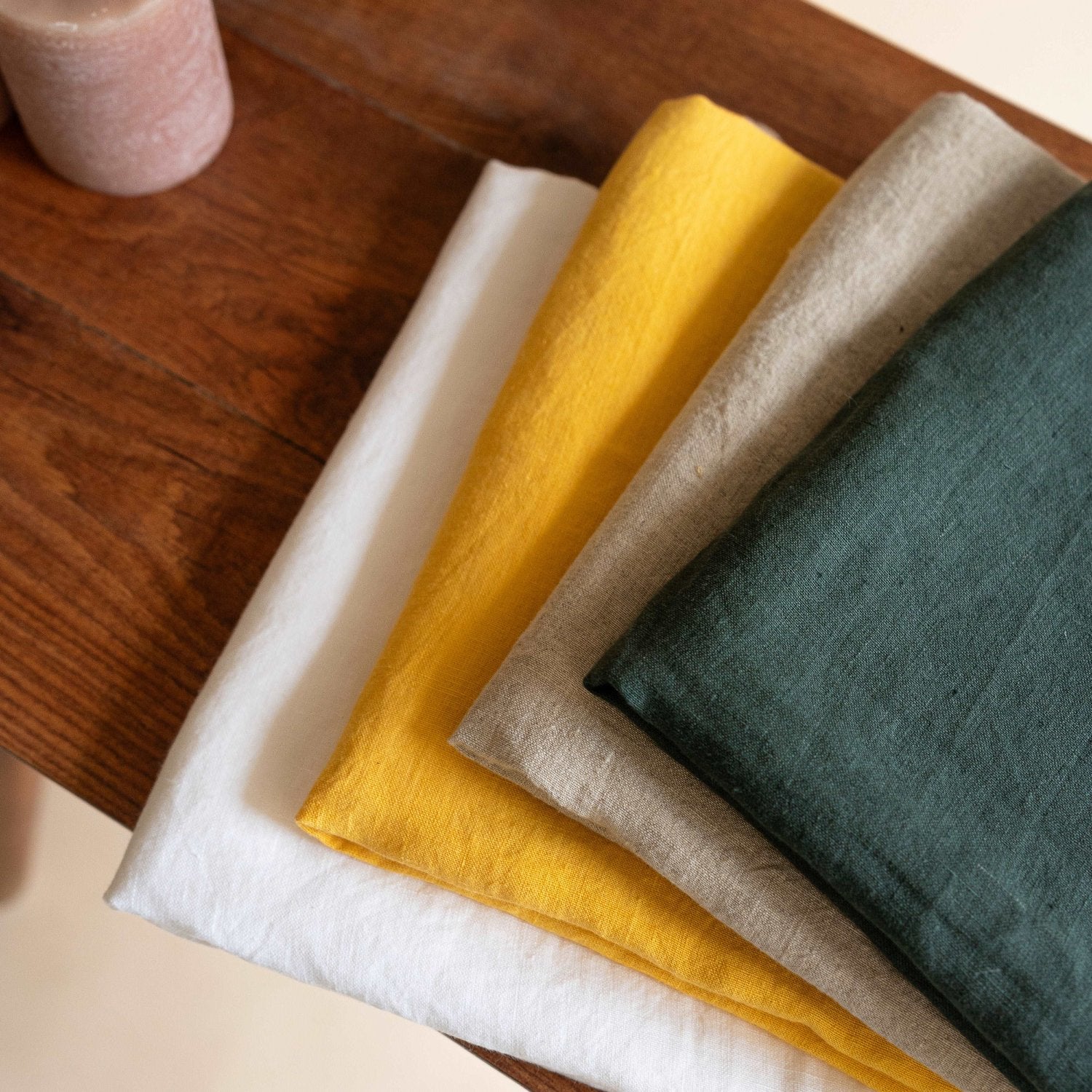 Solid white linen tablecloth neatly folded, showcasing its timeless appeal.