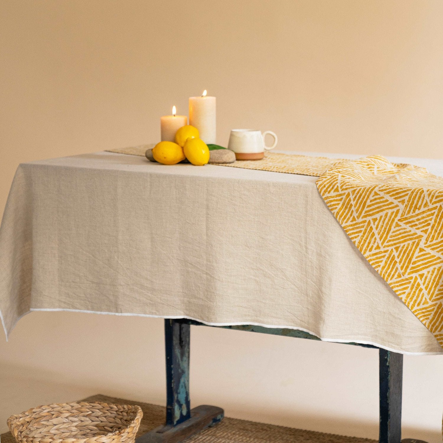 Dining table set with a natural linen tablecloth and neutral dinnerware.