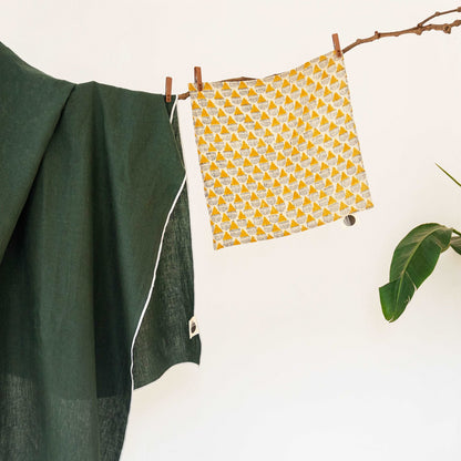 Prisma napkin hanging on a branch, showcasing its abstract design and soft linen texture.