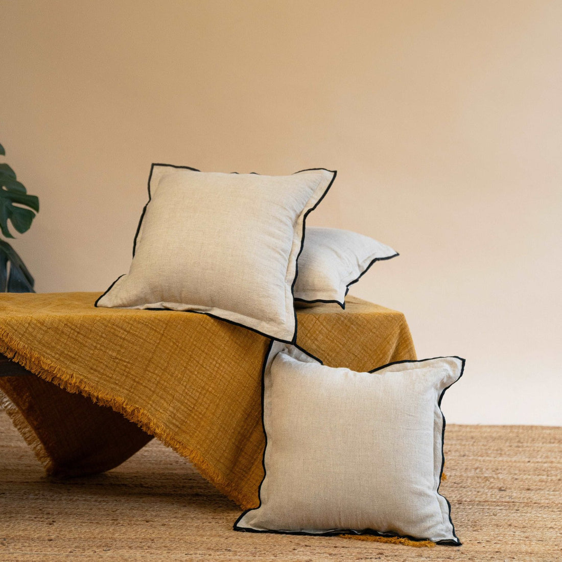 Stack of Oatmeal linen cushions with fillers neatly laid out, emphasizing the durability and craftsmanship of the fabric.