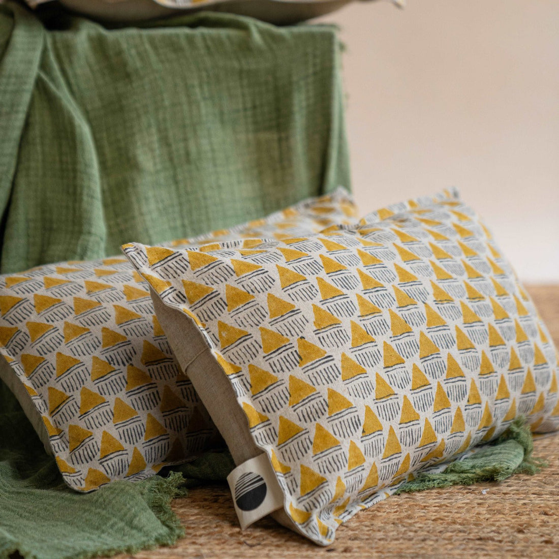 Pair of Prisma hand block printed linen cushion covers in mustard ochre, arranged on a living room floor to enhance the room&