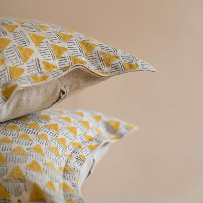 Close-up of the geometric hand block printed Prisma pattern on the mustard ochre linen cushion cover, highlighting the detailed craftsmanship.