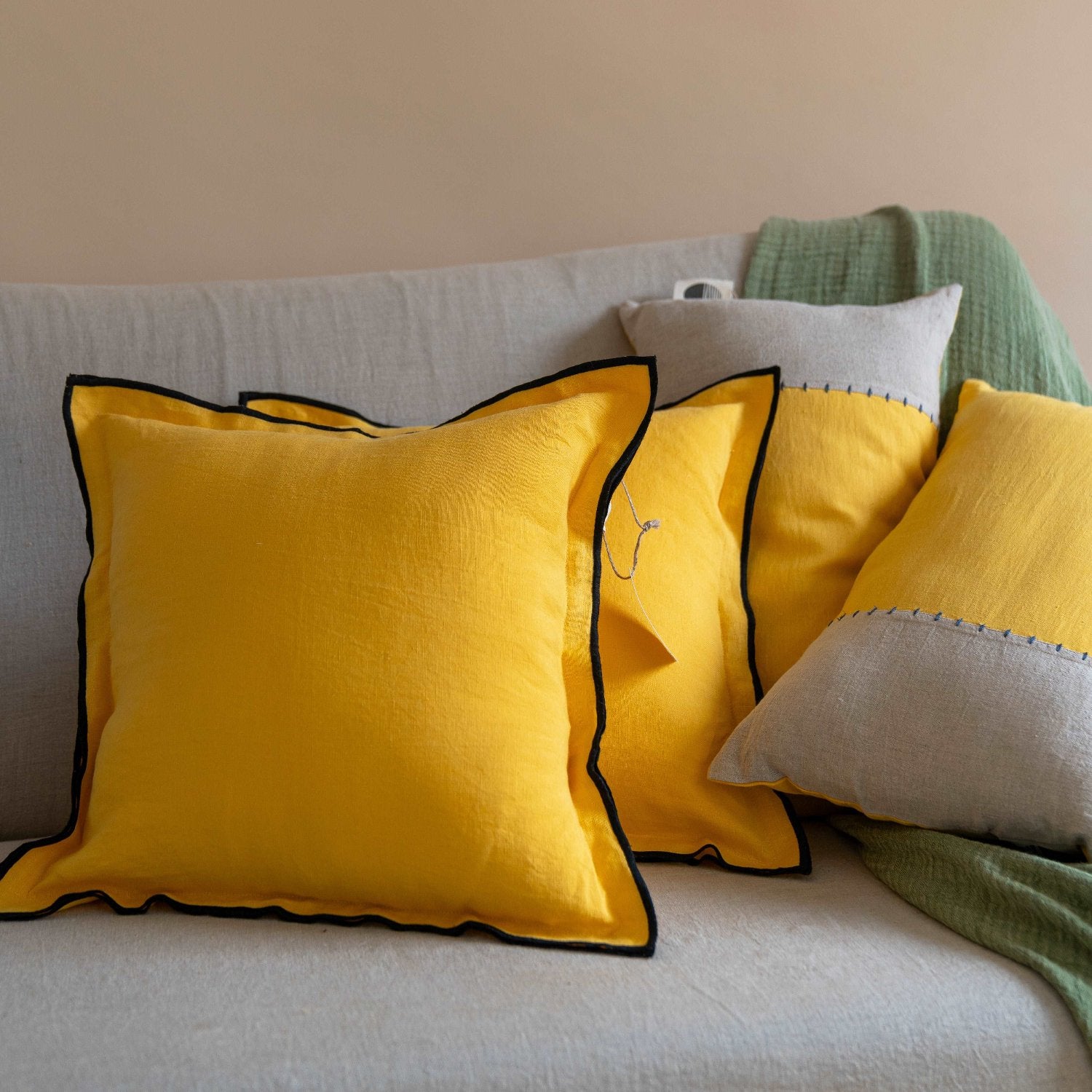 The Summer Yellow linen cushion cover placed on a modern sofa, adding a pop of color to the living room décor.