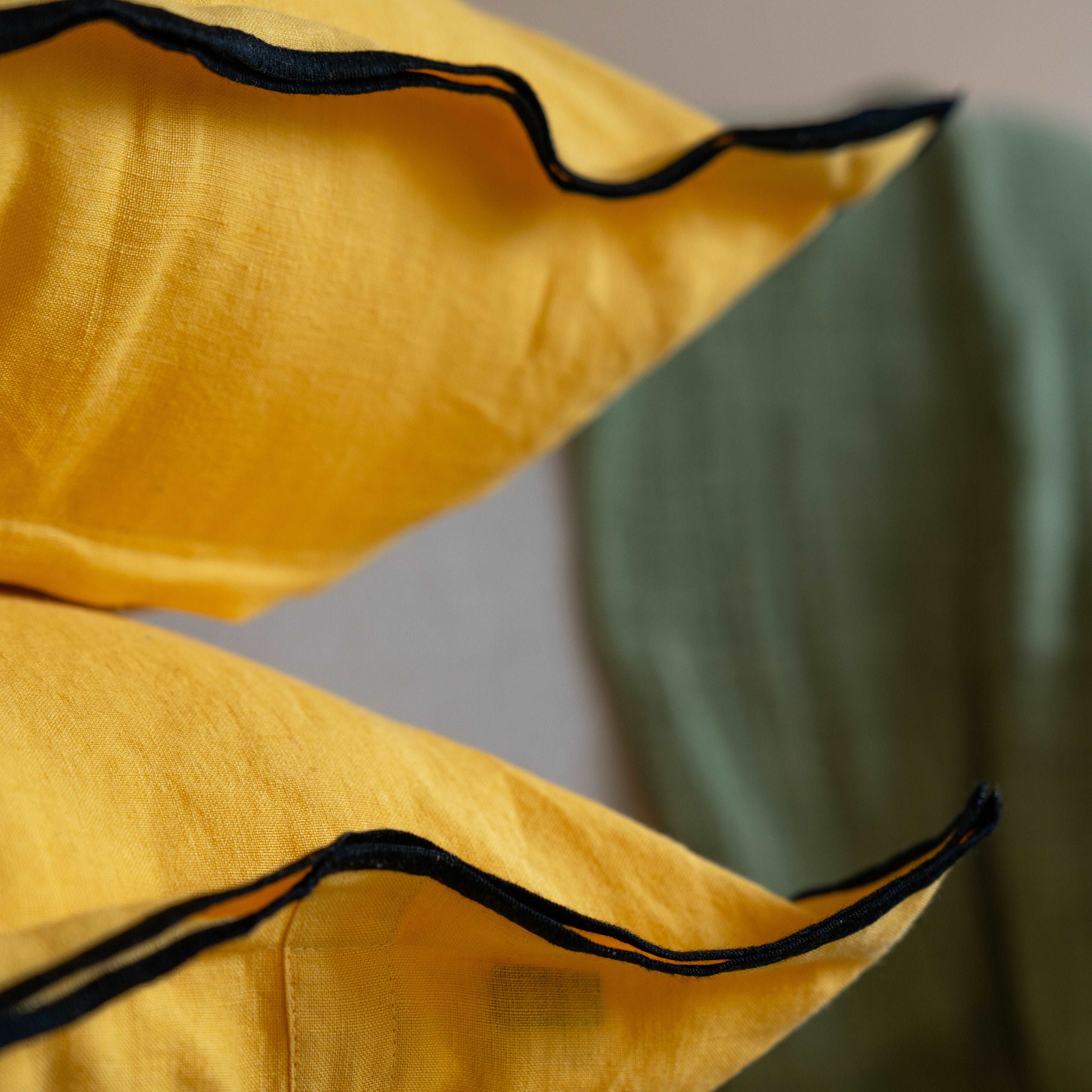 Close-up of the black hem detail on the Summer Yellow cushion cover, showcasing the fine stitching and attention to detail.