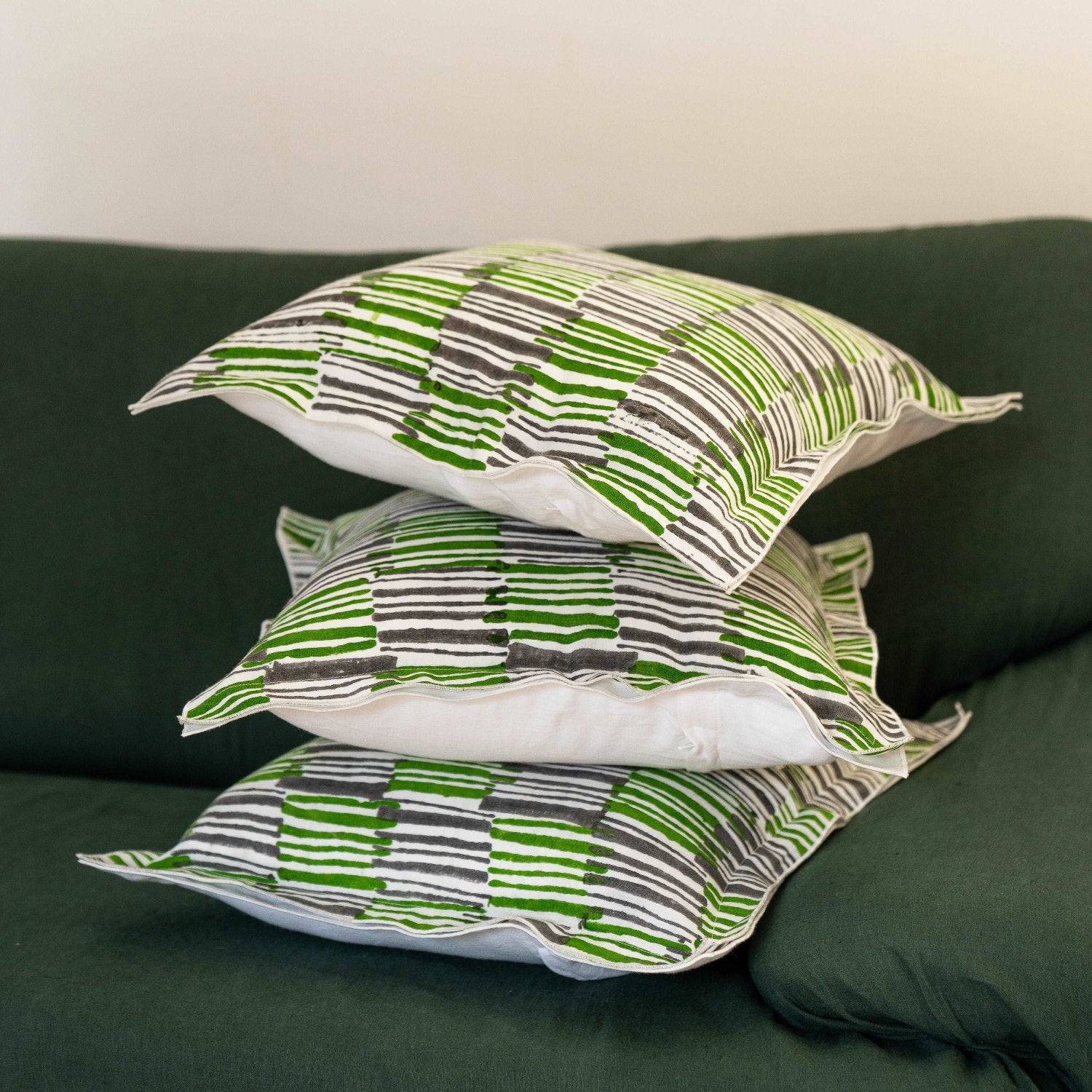 Stack of Mosswood cushion covers neatly folded, showcasing the consistency of the hand block printed pattern.