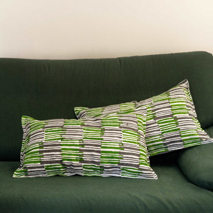 Pair of Mosswood hand block printed linen cushion covers in kale green, arranged on a bed to enhance the bedroom&