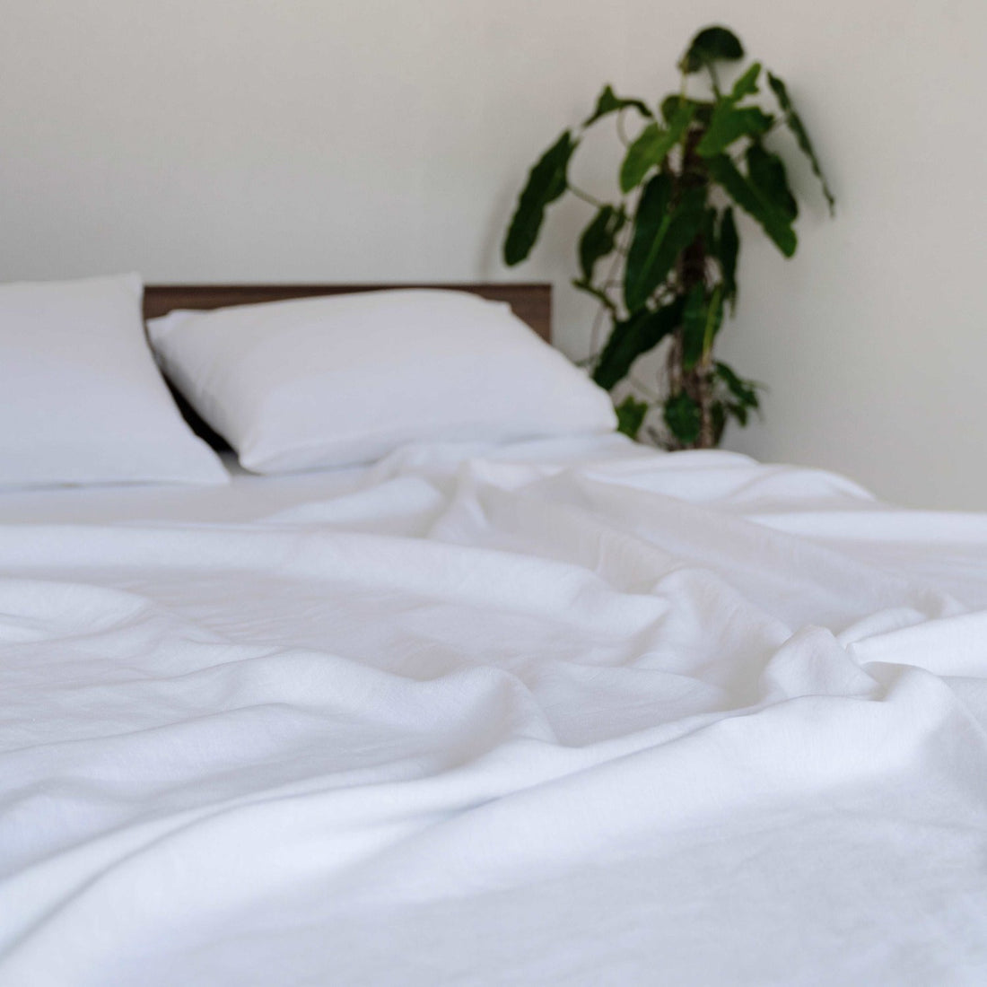 White sheet set styled in an elegant and minimalistic bedroom.